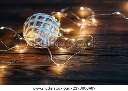 Close up of christmas ball with Chritmas tree lights flickering in background. shallow depth of field. xmas concept.
