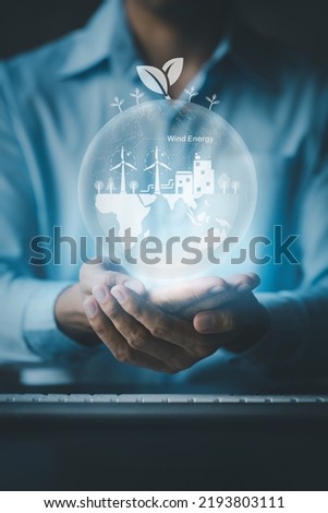 Person with Earth Hologram Renewable Energy, Earth Hologram and Wind Energy Used as Pure Renewable Energy to Reduce High Cost Oil Use, Wind Energy is a Natural that Reduces Global Warming. hot. Royalty-Free Stock Photo #2193803111