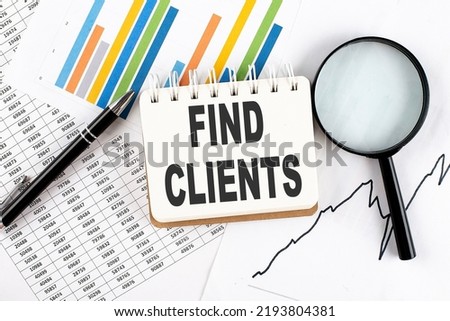 FIND CLIENTS text on a notebook on the graph background with pen and magnifier