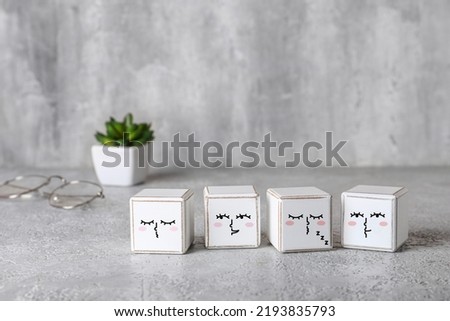White cubes with different drawn emoticons on grunge background
