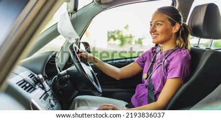 Caucasian female doctor driving her car. Young smiling nurse driving home after a day's work.