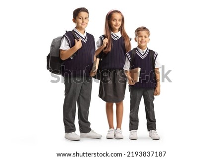 Two boys and one girl in school uniforms carrying backpacks isolated on white background Royalty-Free Stock Photo #2193837187