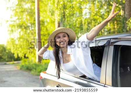 Travel, vacation. A young beautiful woman in a hat sits in a car and smiles, looking into the distance. Lifestyle. High quality photo