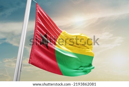 Guinea-Bissau national flag waving in beautiful clouds.
