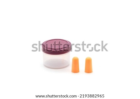Soft orange foam earplugs in a plastic container and a pair of earplugs on a white background.Close-up.The concept of getting rid of noise in a noisy place, hearing protection.High quality photo