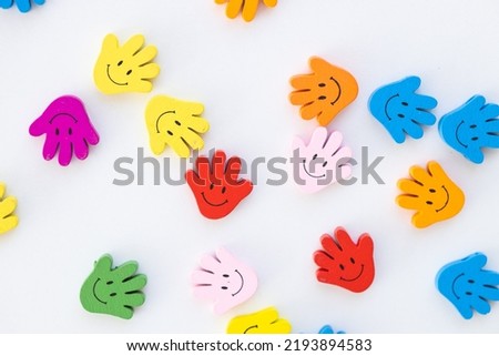 Colored wooden figures in the form hand with smiles on a white background