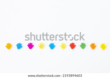 Colored wooden figures in the form hand with smiles on a white background