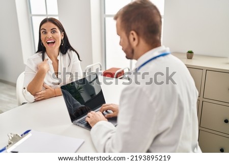 Young hispanic woman at the doctor pointing finger to one self smiling happy and proud 