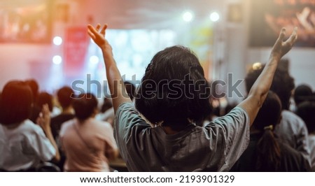 Christian people worship God together.Soft focus of Christian worship with raised hand.