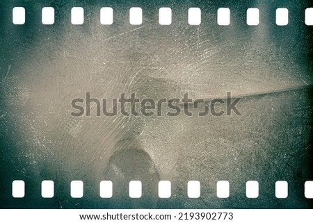Dusty and grungy 35mm film texture or surface. Perforated scratched camera film isolated on white background. Royalty-Free Stock Photo #2193902773