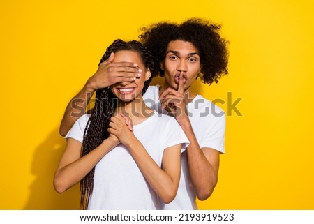 Photo of two cheerful funny people guy show shh symbol cover lady eyes isolated on yellow color background