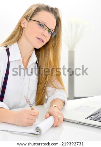 beautiful young woman preparing her report with notebook and pen