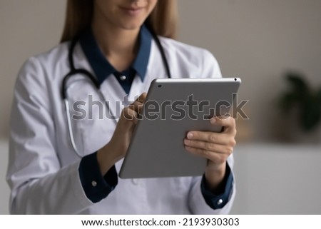 Close up young female general practitioner doctor medical worker holding digital computer tablet in hands, web surfing information or giving distant healthcare advice, modern technology and medicine Royalty-Free Stock Photo #2193930303