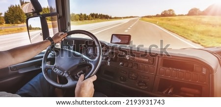 Driver of semi-truck sitting and drining his vehicle Royalty-Free Stock Photo #2193931743