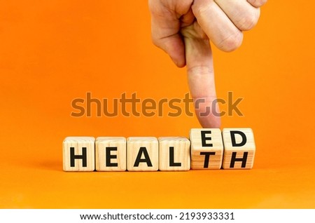 Healed health symbol. Doctor turns wooden cubes and changes concept words Healed to Health. Beautiful orange background. Medical healed health concept. Copy space. Royalty-Free Stock Photo #2193933331