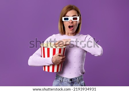 woman watching movie film, holding bucket of popcorn