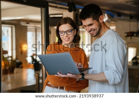 White colleagues discussing project while working with laptop in office indoors Royalty-Free Stock Photo #2193938937