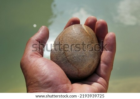 A hand holding a stone. Man and nature.