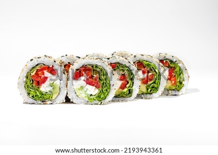 Vegetable roll with feta cheese. Roll stuffed with lettuce, feta cheese, tomatoes and avocado. The filling is wrapped in nori seaweed, rice and topped with white and black sesame seeds. Sushi stands o Royalty-Free Stock Photo #2193943361