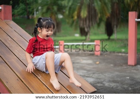 Cute asian girl play on school or kindergarten yard or playground. Healthy summer activity for children. Little asian girl climbing outdoors at playground. Child playing on outdoor playground. Royalty-Free Stock Photo #2193952651