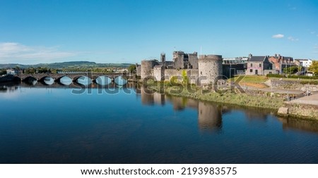 Limerick, Ireland - August 2021 : Panoramic aerial view if Limerick city center. Picture taken during a very sunny day. King John's Castle reflected in the waters of Shannon river.