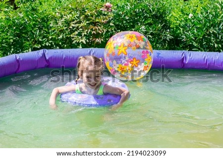 Cheerful girl playing in the pool, summer fun in nature, healthy lifestyle