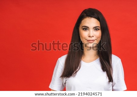 Portrait of happy smiling brunette girl in casual isolated over red background.