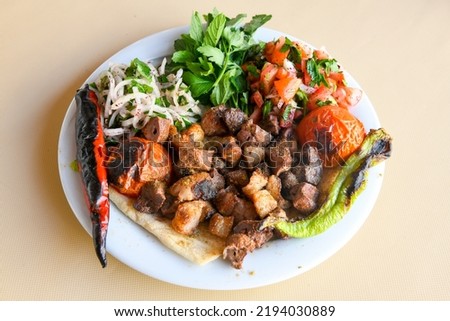 Famous Urfa meat liver, ciger wrapped by lavash with roasted chili pepper, onion and sauce in Sanliurfa, Turkey. Kuzu et ciger sis.