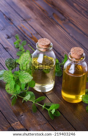 Essential aroma oil with mint  on wooden background. Selective focus.