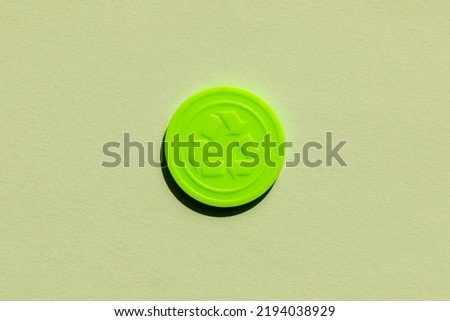 Plastic recycling token coin to be used at a festival or concert to exchange for plastic drink bottles to reduce pastic waste pollution during festive consumerism