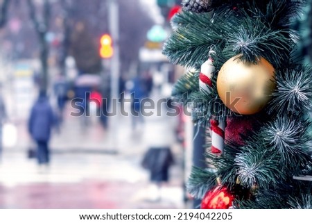 Christmas and New Year tree decorations on a tree branch on a city street on a blurred background on the eve of the holiday
