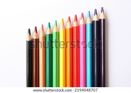 large colored three-sided pencils on a white background