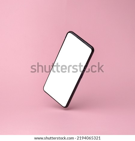 Modern smartphone mockup with white screen flying in antigravity on pink background with shadow. Levitation object in the air. Creative minimal layout Royalty-Free Stock Photo #2194065321