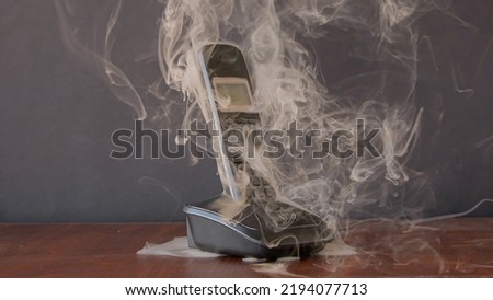 the radiotelephone smokes and burns, sparks fly, a short circuit in household electrical appliances and household appliances.  Royalty-Free Stock Photo #2194077713