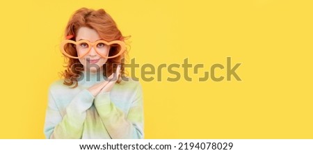 Girl with funny party glasses. happy redhead woman wear funny party glasses on yellow background, positivity. Woman isolated face portrait, banner with copy space.