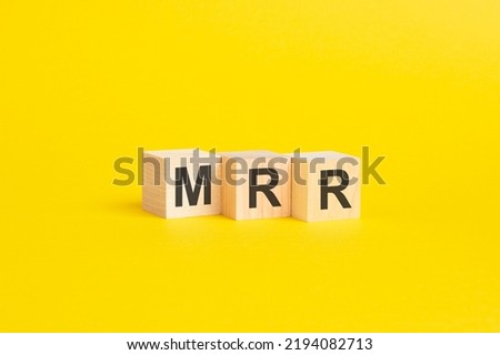 wooden blocks with text MRR - Monthly Recurring Revenue - on yellow paper, business concept