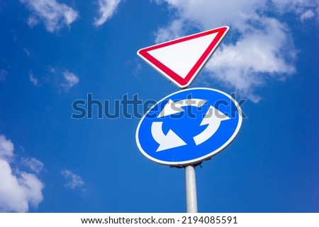 priority road car signs to regulate traffic, shot against the sky close-up