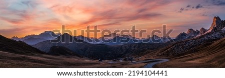 Sun glow and lust sunlight in evening hazy sky. Italian Dolomites mountain panoramic peaceful view from Giau Pass. Climate, environment and travel concept scene. Royalty-Free Stock Photo #2194104441
