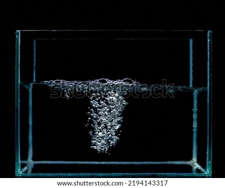 Sponges on the surface of the water, and many water bubbles under the water. Air bubbles and water are in the fish tank. black background