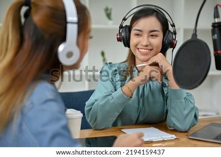 Professional Asian female podcaster or radio host enjoys interviewing her special guest in the studio. broadcaster or podcaster concept