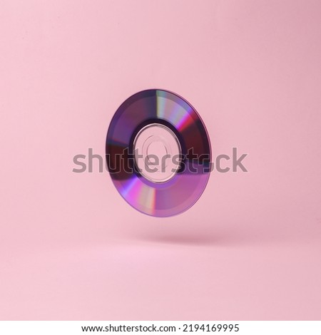CВ disk flying in antigravity on pink background with shadow. Levitation object in the air. Creative minimal layout