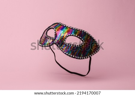 Carnival masquerade mask flying in antigravity on pink background with shadow. Levitation object in the air. Creative minimal layout