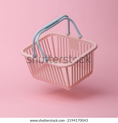Supermarket basket flying in antigravity on pink background with shadow. Levitation object in the air. Shopping, sale concept. Creative minimalist layout