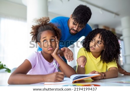 Little girl looking upset while her parents are talking to her in the background Royalty-Free Stock Photo #2194199437