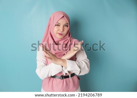 Beautiful Asian Muslim woman with hand gesture pose rejection or prohibition with copy space