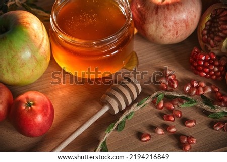 Traditional Jewish new year food card. Red and green apples, pomegranate and honey on wooden background. Happy Rosh Hashanah concept.