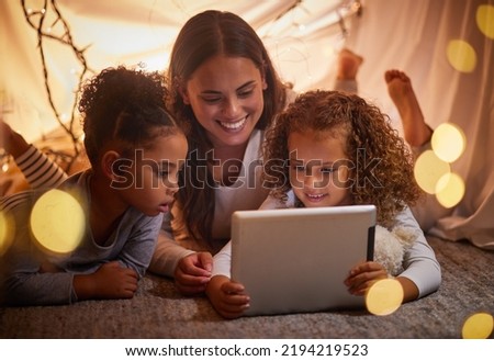 Home tent mother and kids on tablet watch movie or online children entertainment movies at night at house. Happy smile mom or woman and young girl youth family watching or playing fun internet games Royalty-Free Stock Photo #2194219523