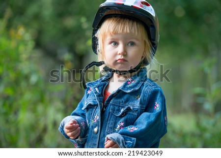 Cute little girl with sport helmet for bicycle, roller or skate