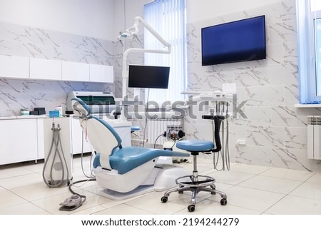 Interior of dental equipment in dentist office in new modern stomatological clinic room. Background of dental chair and accessories used by dentists in blue, medic light. Copy space, text place Royalty-Free Stock Photo #2194244279