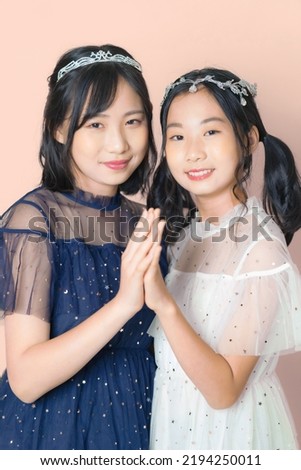 Portrait of two Asian girls in dresses